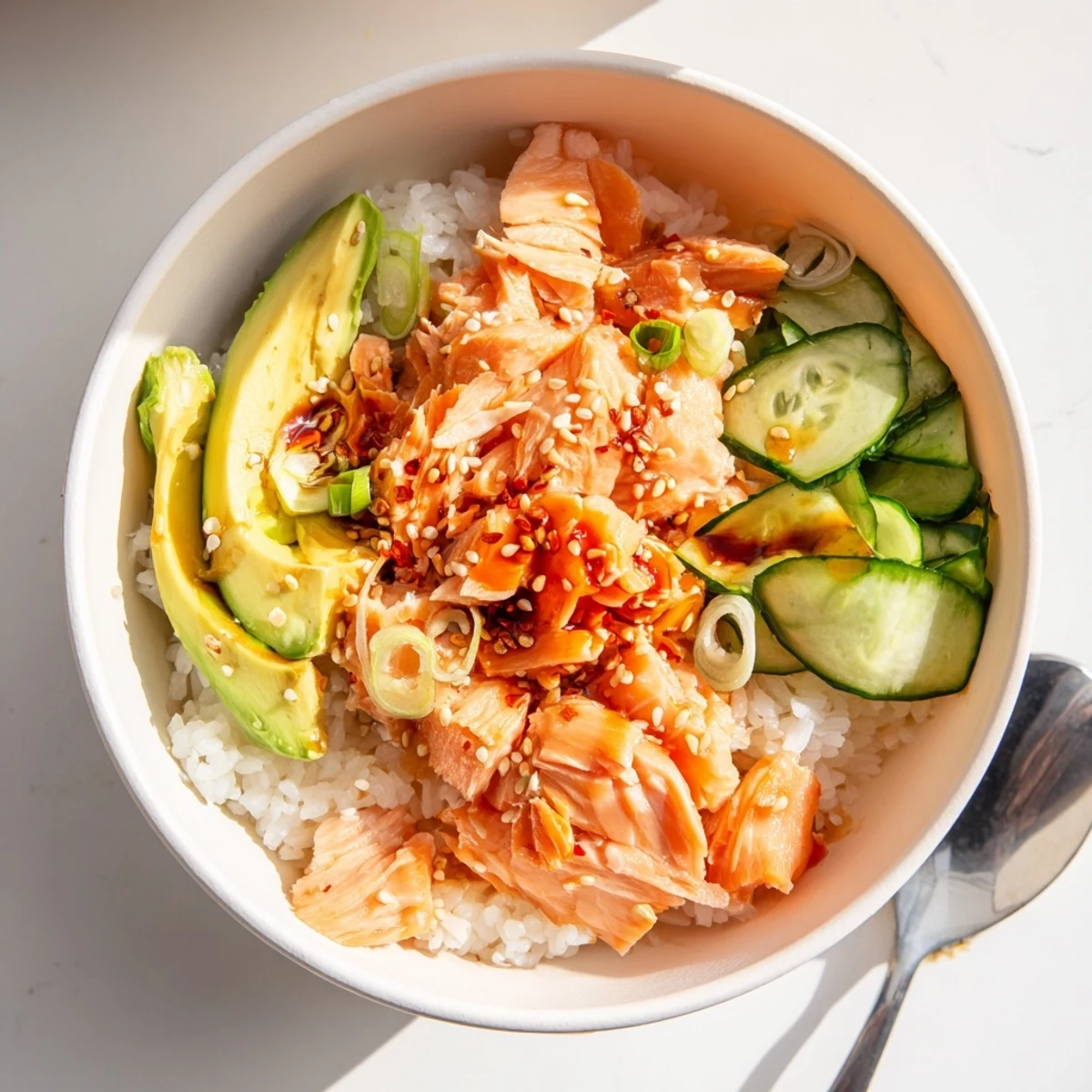 Leftover Salmon and Rice Bowl topped with fresh avocado and cucumber slices.  