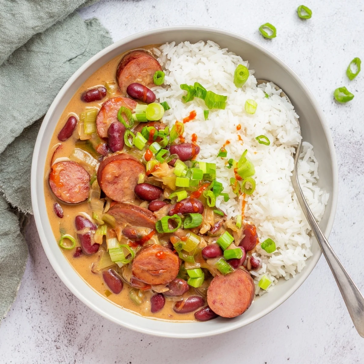 A steaming bowl of Red Beans & Rice topped with fresh green onions.  