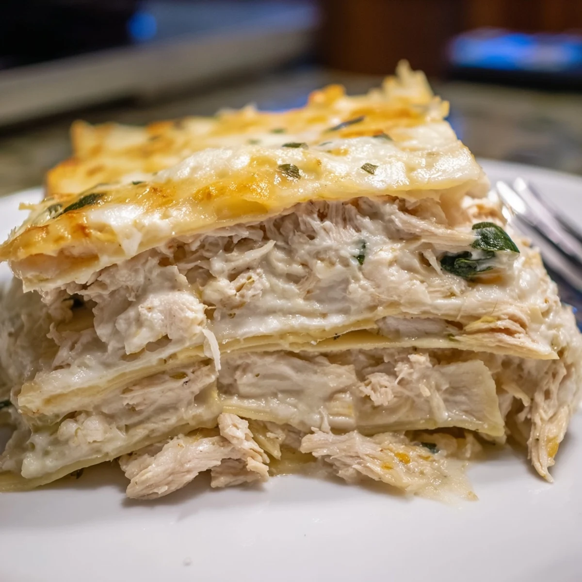 Layers of savory rosemary chicken lasagna topped with melting mozzarella and creamy béchamel.  