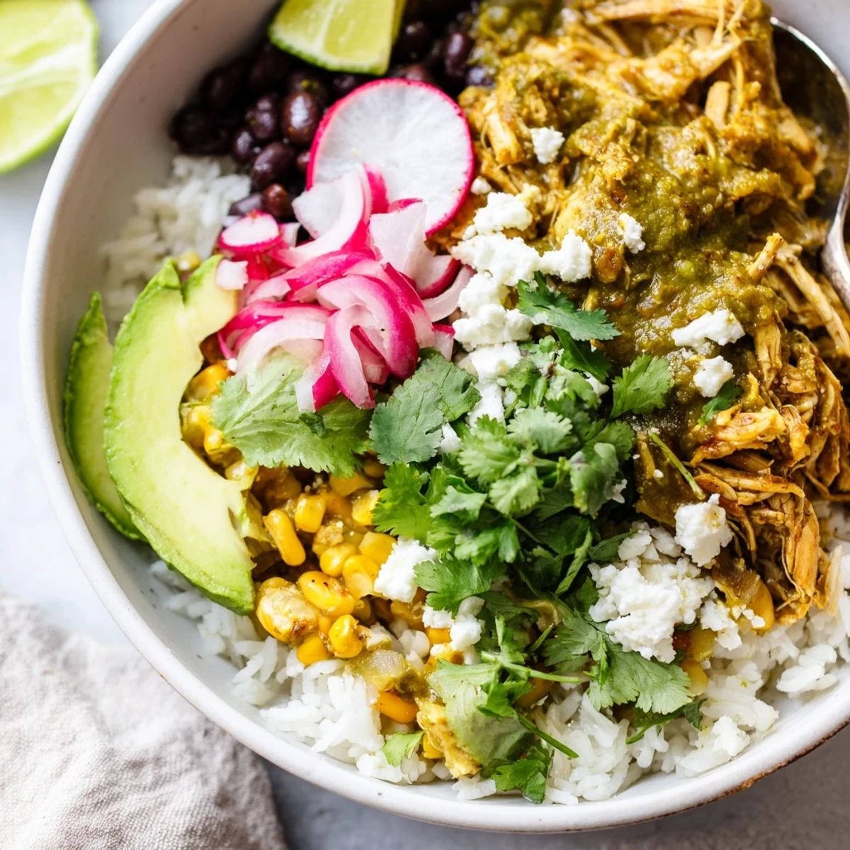 Satisfying Green Enchiladas Rice Bowl drizzled with lime and garnished with cilantro.