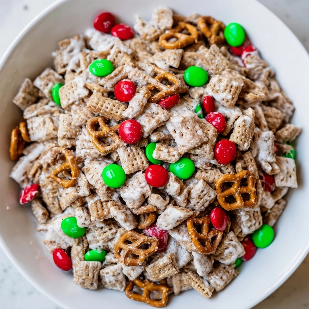 Close-up of golden, sweet Simplified Reindeer Chow loaded with chocolate pieces and crunchy pretzels.