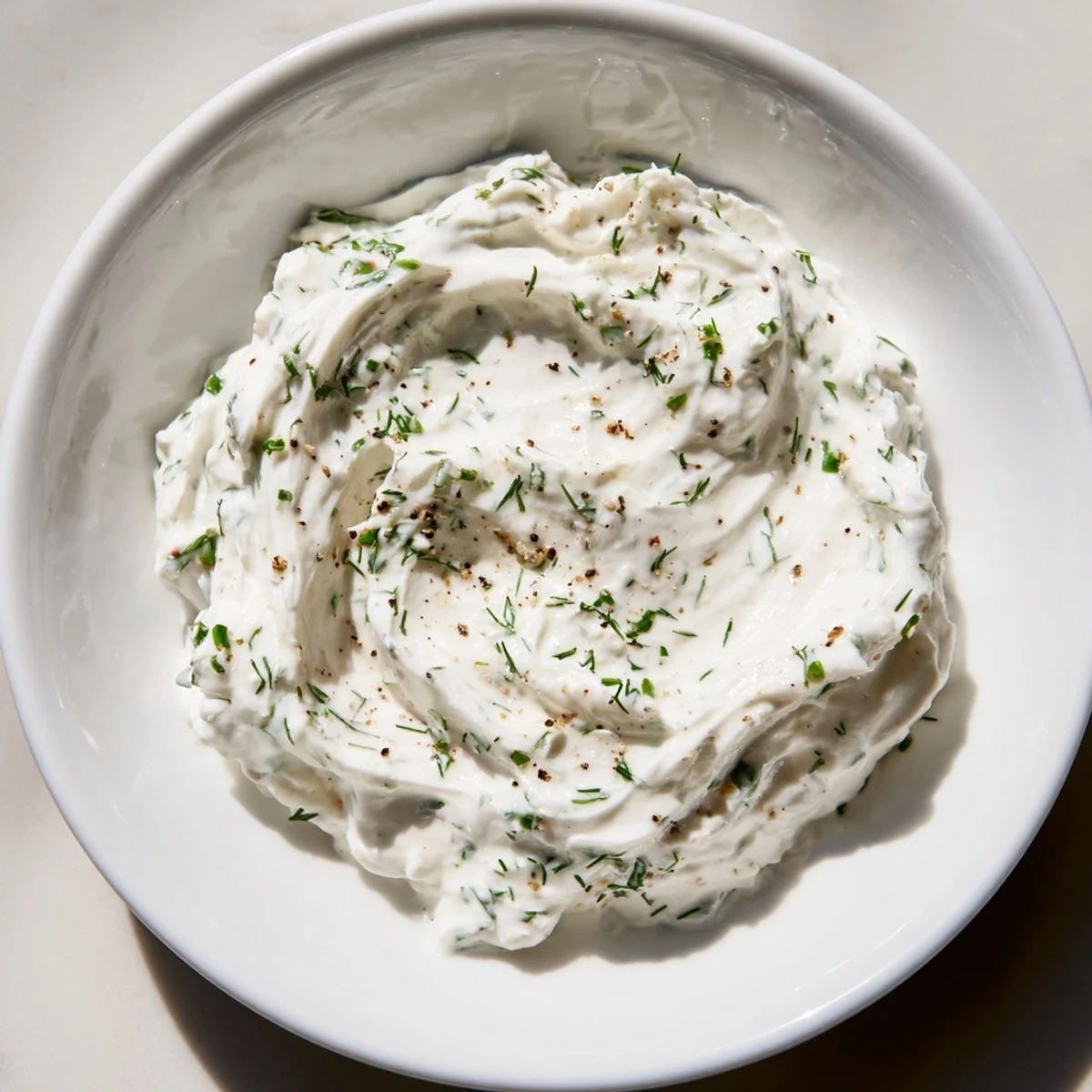Creamy Greek yogurt ranch dip, speckled with herbs, ready to be scooped up with crisp veggie sticks.