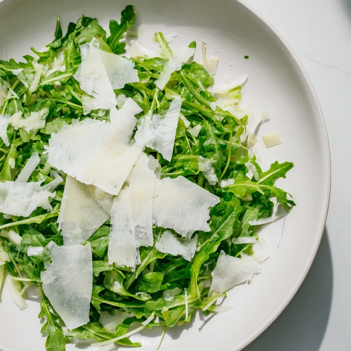 Vibrant Italian arugula salad: peppery arugula leaves coated in a zesty lemon dressing, ready to eat.