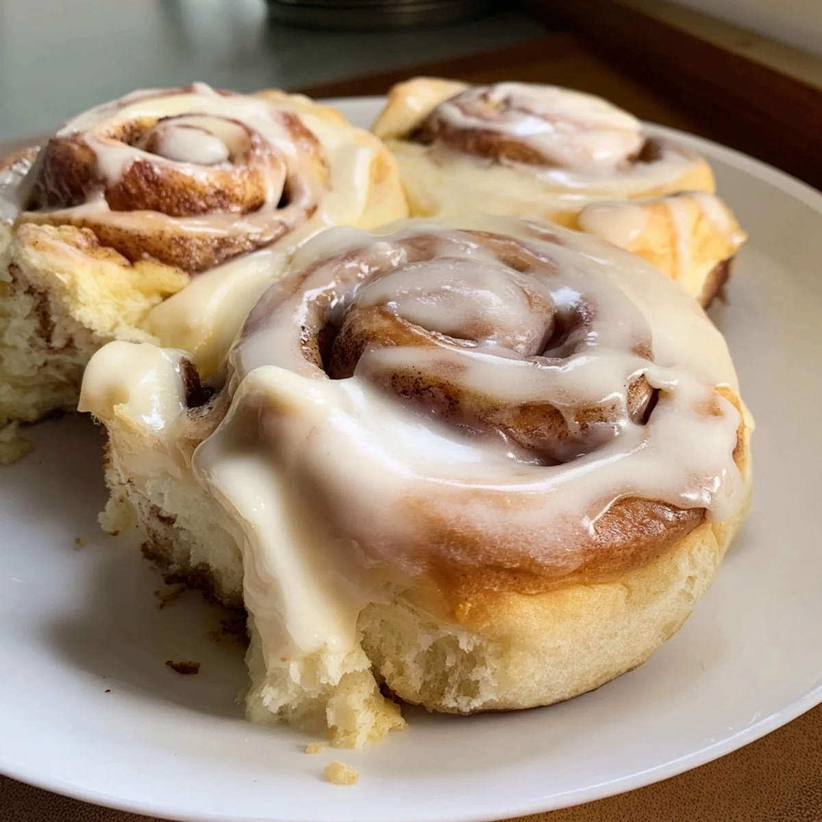 Warm, gooey Pillow Soft Cinnamon Rolls fresh from the oven, glistening with creamy glaze.