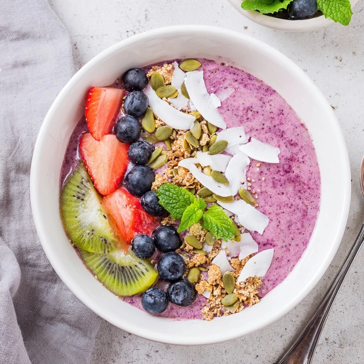 A vibrant Beet and Berry Smoothie Bowl topped with crunchy granola, fresh berries, and sliced kiwi, ready to serve.