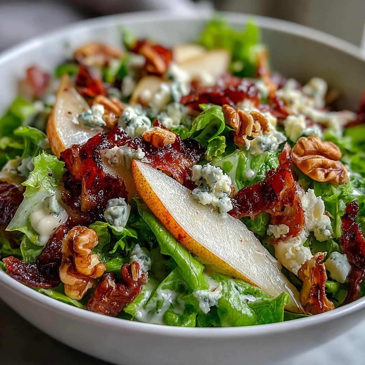 Glistening vinaigrette coats the frisée, pear, and blue cheese in this refreshing bowl. Crispy prosciutto adds a savory crunch to the colorful pear blue cheese salad.