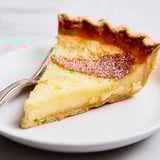 Golden-brown water pie, a nostalgic dessert topped with fresh berries.  