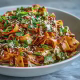 Gochujang Swede Noodles feature roasted swede ribbons and rice noodles tossed in a sweet, spicy gochujang dressing, garnished with sesame seeds and fresh cilantro.