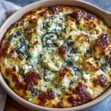 Sliced into squares, this High Protein Spinach Artichoke Bake reveals vibrant green spinach and tender artichoke hearts inside.