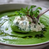 Delicious spring pea soup with cool ricotta swirl and fresh minty drizzle.