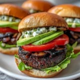 Hearty vegetarian portobello burgers topped with creamy avocado, stacked high and tempting.
