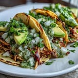 Deconstructed slow cooker salsa verde chicken tacos with fresh toppings and lime.