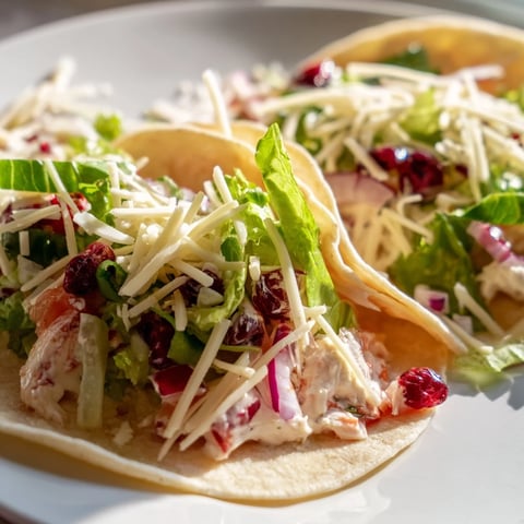 Tangy cranberry jalapeño dip tacos topped with fresh veggies and melted cheese.  