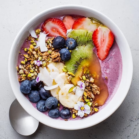 Colorful vibrant smoothie bowls topped with fresh fruits and crunchy pistachios for breakfast.