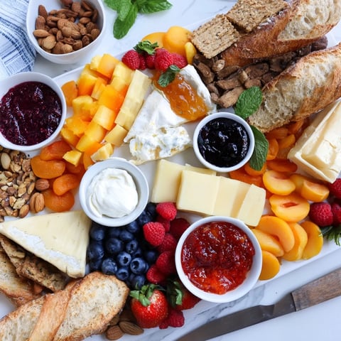 A colorful jam-infused brunch board with fresh fruits and artisan cheeses.  