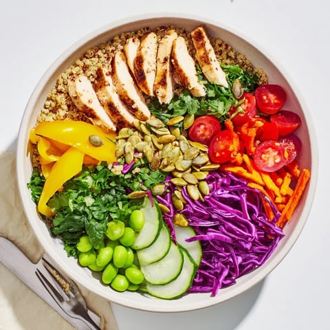 Colorful healthy meal-prep bowls filled with quinoa, vegetables, and grilled chicken.  