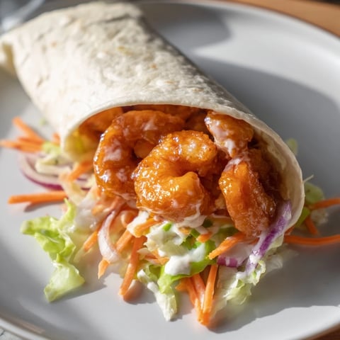 Crispy buffalo shrimp wraps, filled with vibrant veggies, creamy ranch, and spicy, saucy shrimp.