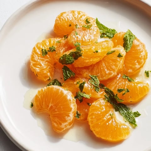 Vibrant clementine and mint winter fruit salad, showcasing juicy citrus segments and fresh green mint.