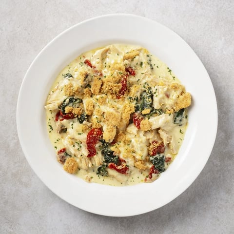 Marry Me Chicken Casserole bubbling in a baking dish, with golden Ritz cracker topping and creamy sauce.
