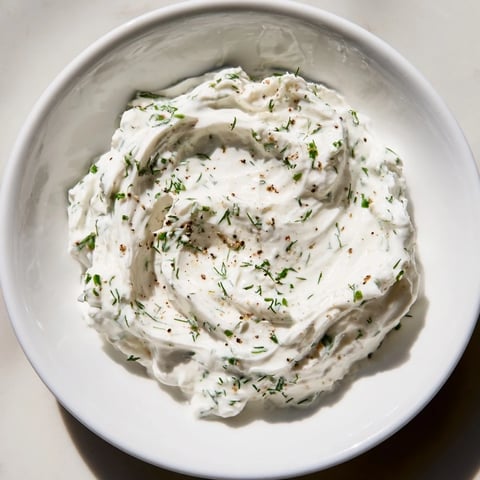 Creamy Greek yogurt ranch dip, speckled with herbs, ready to be scooped up with crisp veggie sticks.