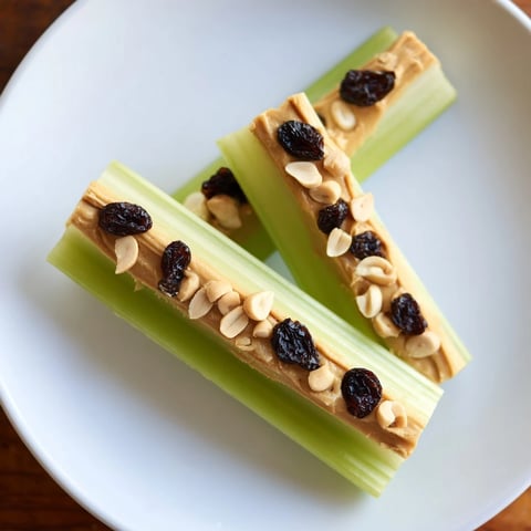 Fresh, crunchy peanut butter celery sticks, a healthy snack, ready to eat on a white plate.