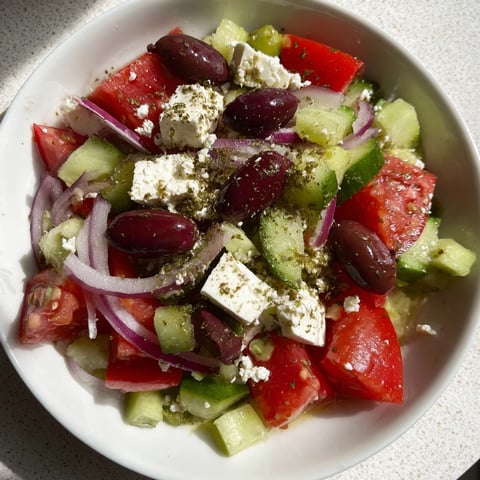 A colorful Mediterranean Salad with vibrant tomatoes and creamy feta cheese, ready to enjoy.