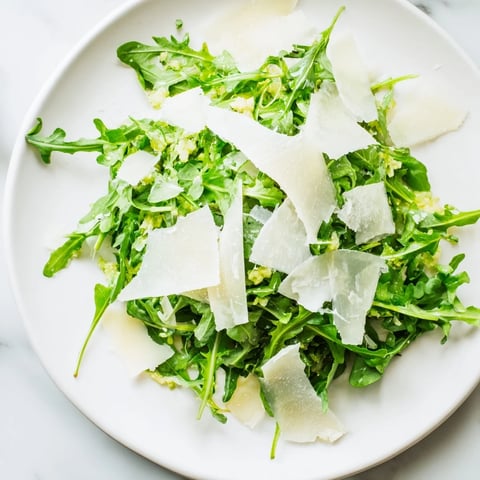 Fresh arugula salad with a bright lemon dressing, Parmesan shavings, and flavorful shallots.
