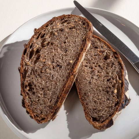 Golden-crusted Estonian Leib sourdough loaf, aromatic with caraway, ready to slice for serving.