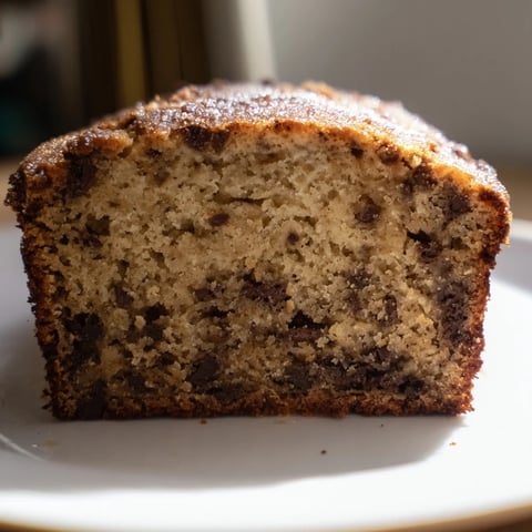 Fluffy slices of golden Banana Bread, studded with chocolate chips, ready to enjoy.
