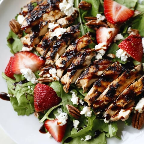 Grilled chicken slices, fresh strawberries, and creamy goat cheese on mixed greens, drizzled with a honey balsamic glaze.