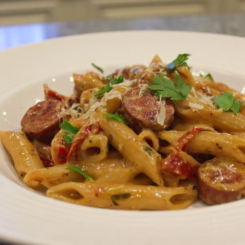 Enjoy a steaming bowl of Smoked Sausage Cajun Alfredo; the penne pasta is coated in a spicy Alfredo sauce.
