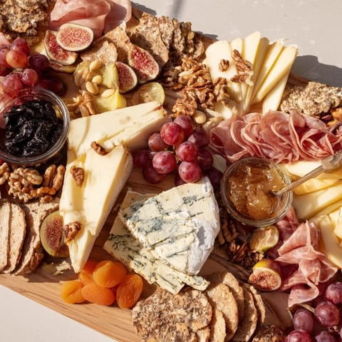 A beautifully arranged 2026 Wine Pairing Board overflowing with cheeses, fruits, and meats, ready to enjoy.