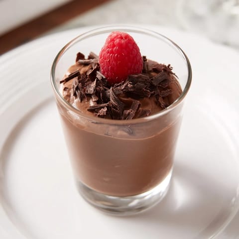 Creamy chocolate mousse dessert cups with fluffy whipped peaks, promising a rich and sweet experience.