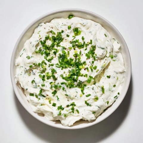 Brightly colored Veggie Ranch Dip, featuring fresh herbs, served with crisp, crunchy carrot sticks and celery.