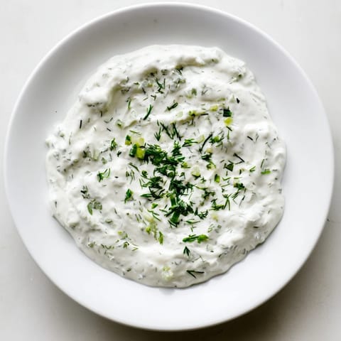 A vibrant bowl of flavorful Greek Yogurt Ranch Dip, perfect for dipping crunchy vegetables.