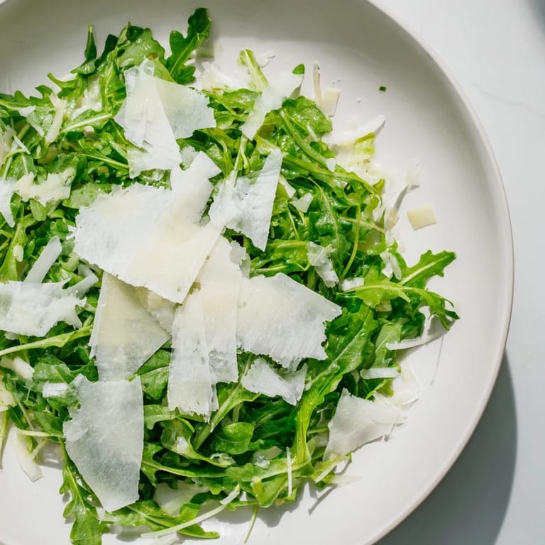 Vibrant Italian arugula salad: peppery arugula leaves coated in a zesty lemon dressing, ready to eat.