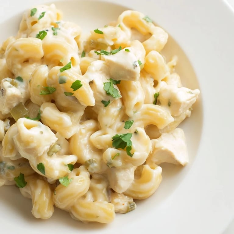 This cozy Green Chili Chicken Mac is served hot in a rustic cast-iron skillet, ready to enjoy with sliced jalapeños and a bright side salad.  