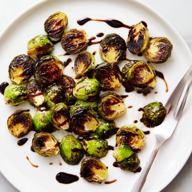 Golden-brown Roasted Brussels Sprouts with Balsamic drizzle on a plate, ideal for holiday meals.